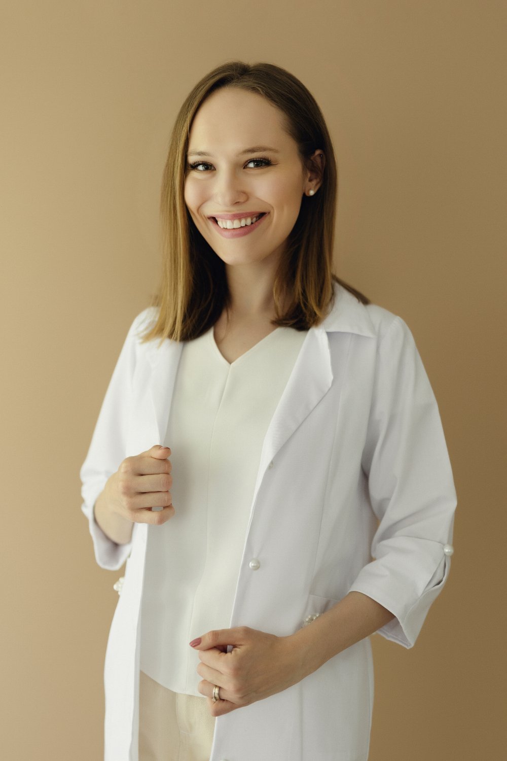 Dr. Georgiana Gheba zâmbind, în halat alb